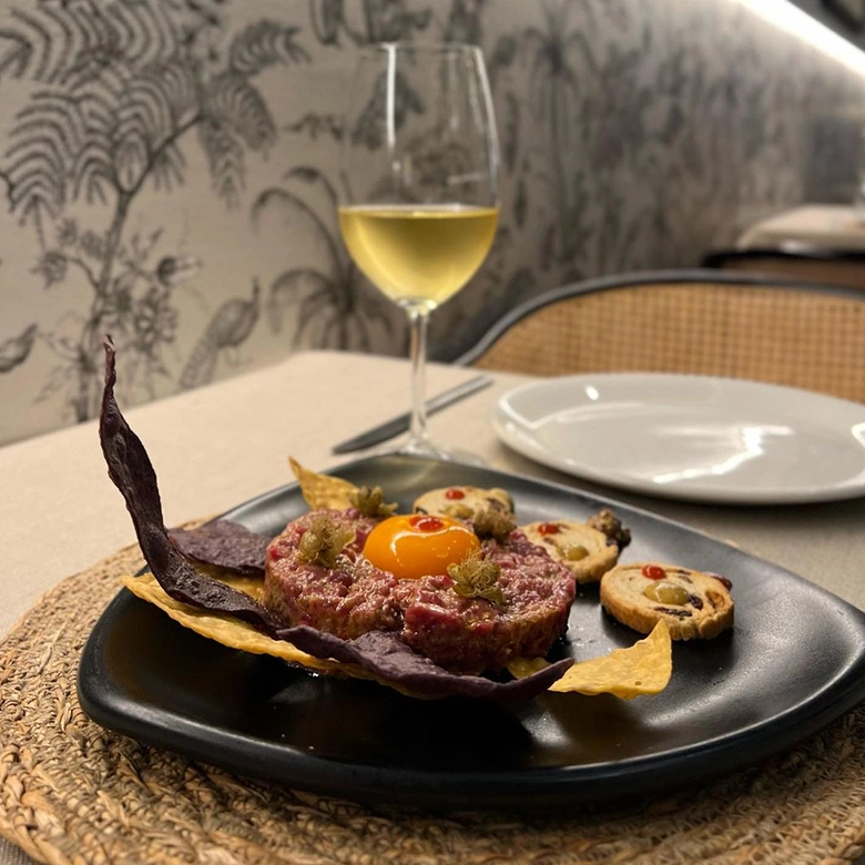 plato de tartar y copa de vino